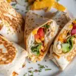 Sliced Chipotle Ranch Grilled Chicken Burrito showing grilled chicken, lettuce, tomato, and cheese