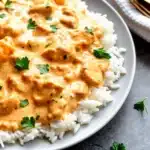 Creamy Smothered Chicken and Rice cooked in a cast iron skillet with herbs